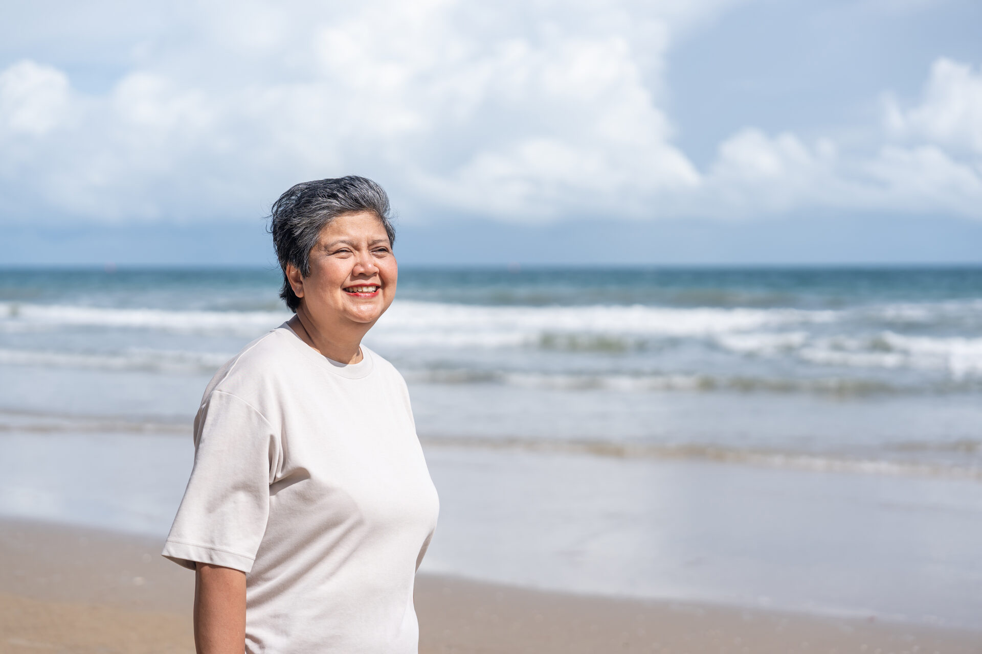 Femme senior souriante face à la mer
