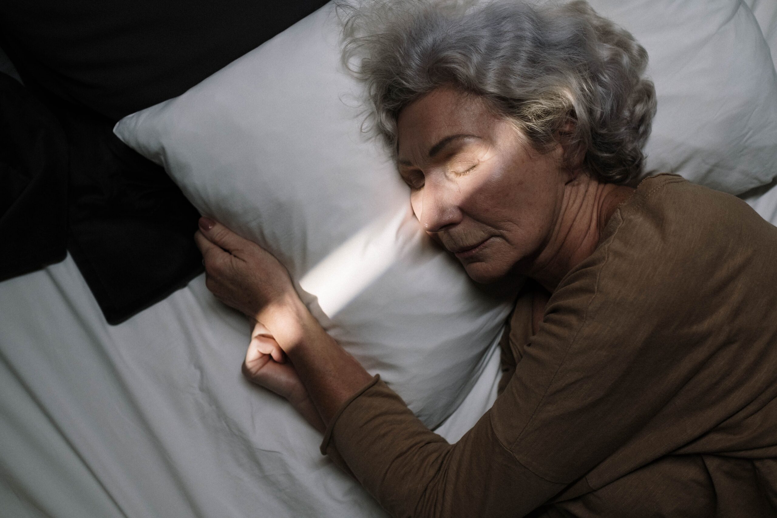 Femme senior endormie paisiblement, illustrant les effets de la mélatonine sur le sommeil